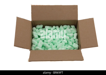 Brown cardboard box with green polystyrene packaging peanuts Stock Photo