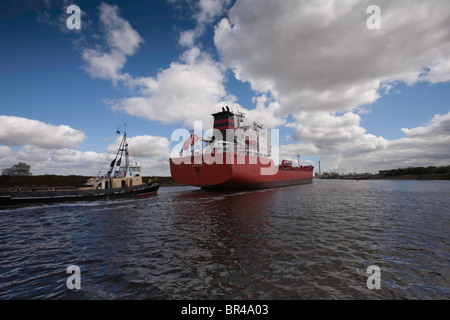 Ship being towed up the Manchester Ship Canal to Ellesmere Port on Merseyside Stock Photo