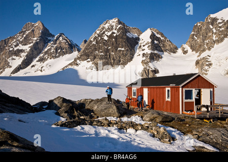 A group of skiers relax at a mountain hut near the Karale Glacier on Ammassalik Island, Greenland. Stock Photo