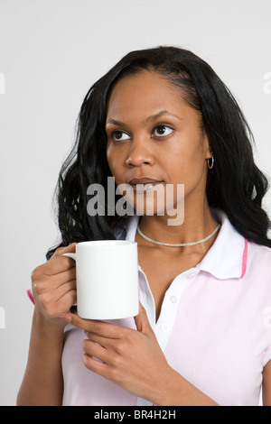 A young African American business woman in a contemplative mood while drinking coffee. Stock Photo