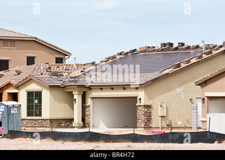 Integral solar roofing panels are being built into the roof of a new home under construction in Arizona. Stock Photo