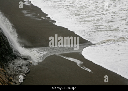 ALAMERE FALLS and PACIFIC OCEAN WAVES on a black sand beach on the COAST TRAIL - POINT REYES NATIONAL SEASHORE, CALIFORNIA Stock Photo