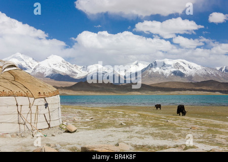 Kirghiz people's yurts by Karakuli Lake, Mt. Kunlun in the distance, Pamir Plateau, Xinjiang, China Stock Photo