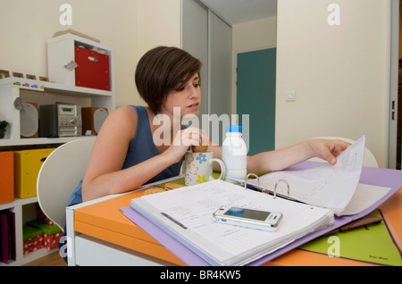 Student studying / revising in her university / college apartment with her breakfast Stock Photo