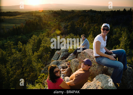 Friends resting on rocks in remote area Stock Photo