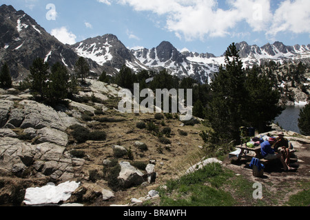 Hikers resting at 2318m Refugi JM Blanc lodge on Estany Tort de Peguera in Sant Maurici National Park Pyrenees Spain Stock Photo