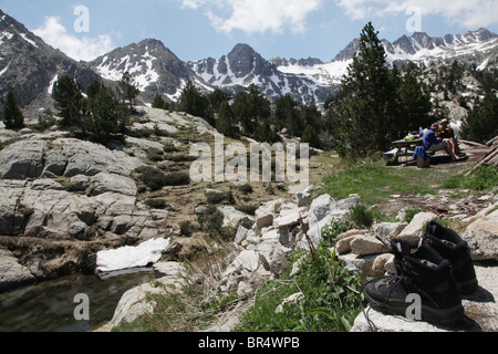 Hikers resting at 2318m Refugi JM Blanc lodge on Estany Tort de Peguera in Sant Maurici National Park Pyrenees Spain Stock Photo