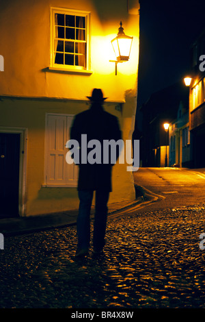 Man walking down cobbled street in Norwich Stock Photo