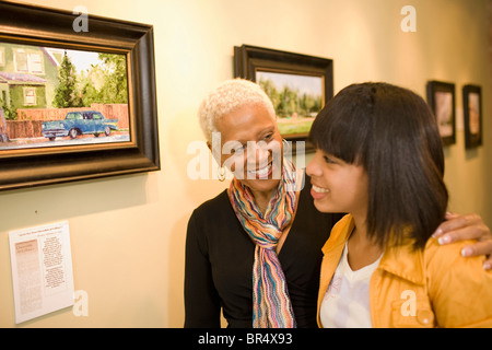 Grandmother and granddaughter hugging in gallery Stock Photo