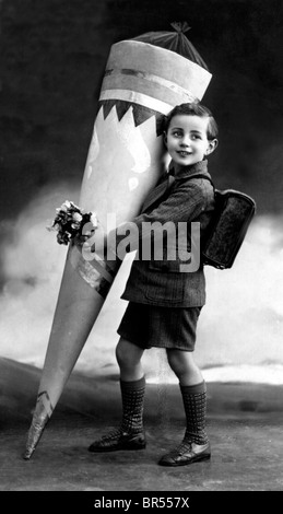 Historic photograph, child carrying a large Schultuete, school bag, a traditional gift in Germany, given to children on their Stock Photo