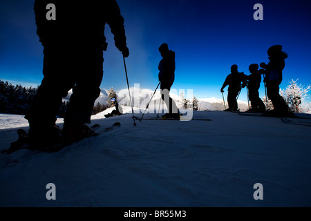 Low angle view of skiers silhouetted against a clear blue sky while skiing on Mt. Washington in New Hampshire. Stock Photo