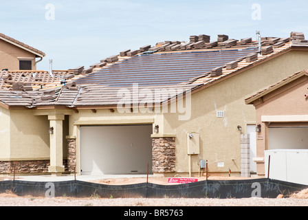 Integral solar roofing panels are being built into the roof of a new home under construction in Arizona. Stock Photo