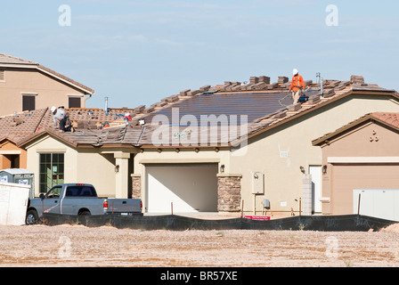 Integral solar roofing panels are being built into the roof of a new home under construction in Arizona. Stock Photo