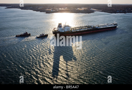Oil tanker being piloted by tug boats into Portland Harbor Maine. Stock Photo