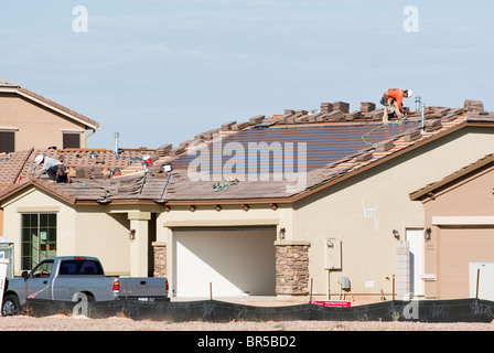 Integral solar roofing panels are being built into the roof of a new home under construction in Arizona. Stock Photo