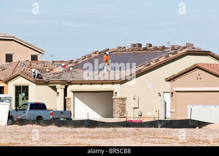 Integral solar roofing panels are being built into the roof of a new home under construction in Arizona. Stock Photo