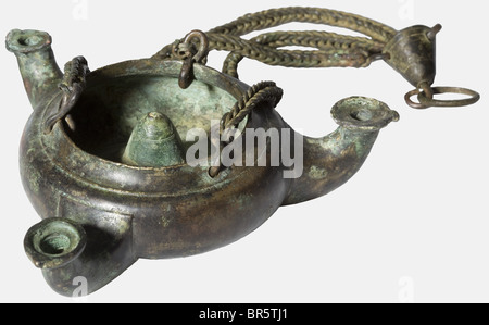 A Roman bronze lamp with three nozzles, 1st/2nd century A.D. Round with open top, bulbous oil container with an erected cone in the middle of the domed bottom and three curved nozzle arms. Complete with three chain suspension and top-piece. Height including chains 24 cm, 11.6 cm in diameter. Beautiful, dark green patina, one minute hole, otherwise completely intact. Provenance: Collection Dr. M., Oberhausen, 1950s. historic, historical, 20th century, ancient world, ancient world, ancient times, object, objects, stills, clipping, cut out, cut-out, cut-outs, Stock Photo