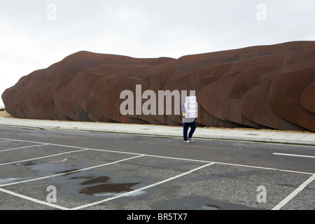 A man walking passed the East beach café in Littlehampton carrying a stack of boxes. Stock Photo