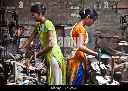 Two young women making plastic mats in the city of Bhavnagar, Gujarati State. Child labour is common in this area. Stock Photo