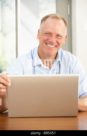 Middle Aged Man Using Laptop At Home Stock Photo