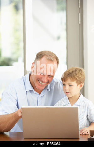 Father And Son Using Laptop At Home Stock Photo
