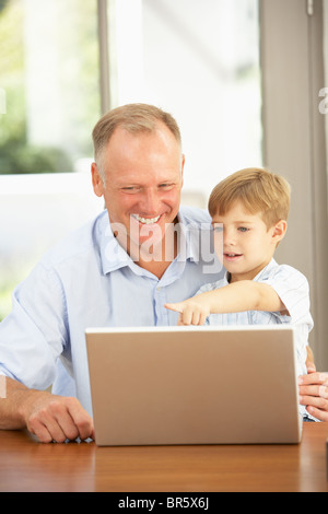 Father And Son Using Laptop At Home Stock Photo