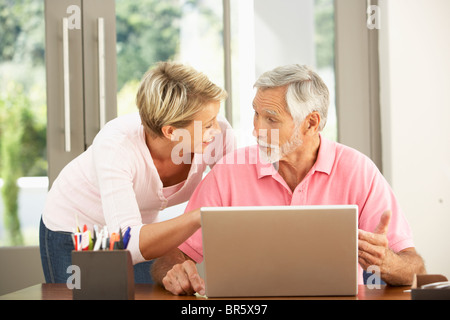 Adult Daughter And Senior Father Using Laptop At Home Stock Photo