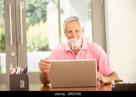 Senior Man Using Laptop At Home Stock Photo