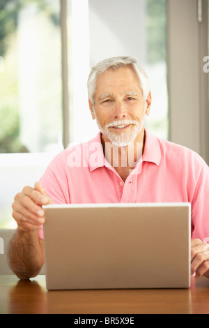 Senior Man Using Laptop At Home Stock Photo