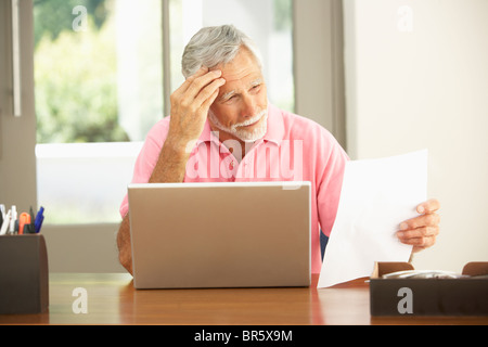Senior Man Using Laptop At Home Stock Photo
