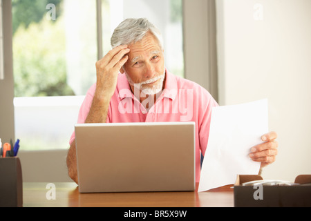 Senior Man Using Laptop At Home Stock Photo