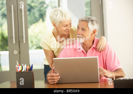 Senior Couple Using Laptop At Home Stock Photo