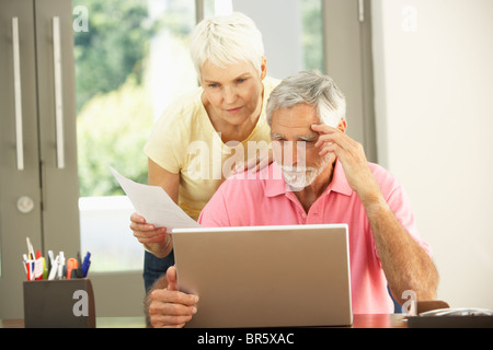 Worried Senior Couple Using Laptop At Home Stock Photo