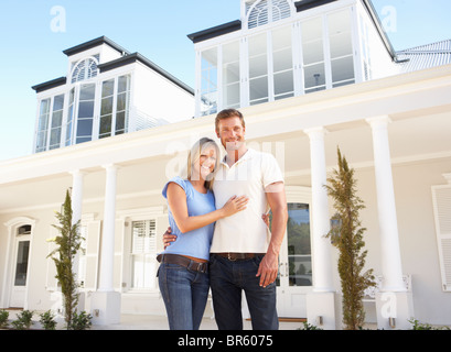 Young Couple Standing Outside Dream Home Stock Photo