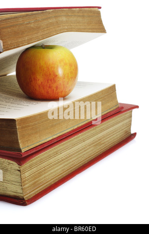 Red apple in between pages of old book on white background Stock Photo