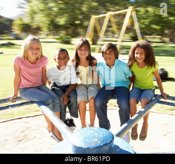 Group Of Children Riding On Roundabout In Playground Stock Photo