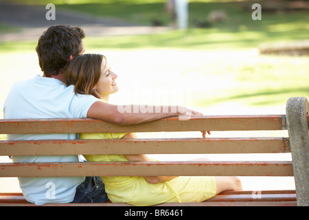 Couple Sitting Together On Park Bench Stock Photo