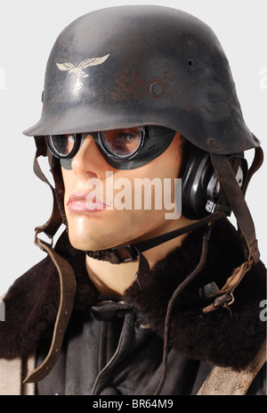 A uniform ensemble for a Luftwaffe gunner., A flier's protective helmet, made for collectors using a Model 42 helmet. Green plastic protective goggles with tinted lenses, inscribed 'Auer Neophan'. Single earphone (defective). A KW 1/33 blue buckskin flying suit with a brown sheepskin collar, fleece lining, and straight button row. All closures fastened with buttons (field grey) instead of zippers. Field grey linen gloves with one trigger finger, grey leather trim and a 1941 maker's stamp. A road map for northern France and England. Blue linen cartridge bag, sta, Stock Photo