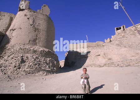 A child walks below the old walls and citadel of the town of Ghazni Afghanistan Stock Photo