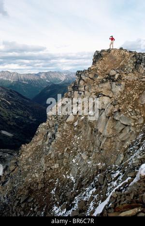 Hiking in Coast Mountains, BC, British Columbia, Canada - Hiker standing on Cliff Edge overlooking Mountain Valley View / Vista Stock Photo