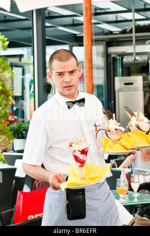 Waiter at work, walking with Ice-Cream glasses, Zagreb, Croatia. Stock Photo