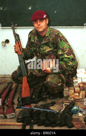 A British Paratrooper pose with captured  weapons in Pristina, Kosovo. Stock Photo