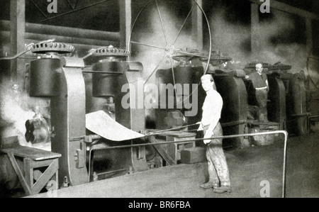 This early 1900s photo shows an Inland Steel company worker rolling out a sheet of steel. Stock Photo