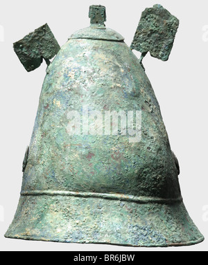 A Hellenistic Pilos type helmet, 4th century B.C. Bronze helmet with a tall conical skull. The flaring rim bordered by two raised bands. Pairs of holes on either side with soldered, pierced disk appliqués bearing wheel decoration. The crest reinforced by a cap with chase decorated edge (ancient repair?) topped by a riveted crest holder. Fragments of two riveted horn attachments on either side. Height 23.5 cm, weight 798 g. Blue-green patina with soil occlusions. The skull glued and supplemented. The inside reinforced with fibreglass. Slightly deformed, intensel, Stock Photo