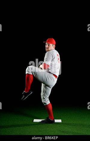 A baseball player winding up to pitch Stock Photo