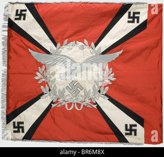 A flak artillery banner., Made entirely of silk with silver fringe on three edges. Red with a white disk on both sides surrounded by a silver embroidered laurel wreath. One side displays a silver embroidered Luftwaffe eagle in the centre spreading its wings beyond the wreath, and the other disk bears an iron cross. Four diagonal white rays with black edging, widening toward the corners, each bearing a silver-edged, black silk swastika at the corner. Unfaded colours. Unnoticeable traces of nails on the pole sleeve, barely noticeable stains. Dimensions 140 x 125 , Stock Photo
