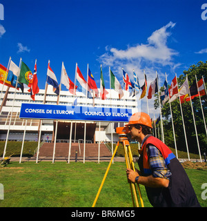 Land surveyor taking measures with a theodolite in front of Council of Europe building, Strasbourg, Alsace, France Stock Photo
