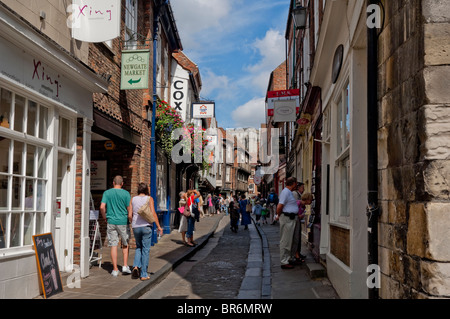 People tourists visitors walking along The Shambles in the city centre in summer York North Yorkshire England UK United Kingdom GB Great Britain Stock Photo