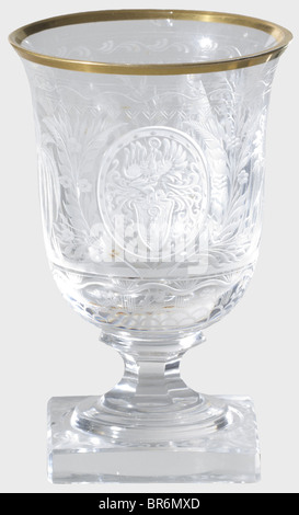 Hermann Göring - a sherry glass, from a hunter's table service. Cut and faceted crystal glass with gold rim (chipped). On the viewing side an Oriental princess seated in a palm grove playing flute to a peacock. The Göring family arms surmounted by a helmet is set in a medallion on the reverse side. Rich floral decoration. Six-sided stem on square foot. Height 10 cm. Provenance: Voluntary auction of the former possessions of Hermann Göring, Neumeister, formerly Weinmülller, 157th auction, 25 October 1974, lot 3061. Presumably a gift for Göring's 50th birthday on, Stock Photo
