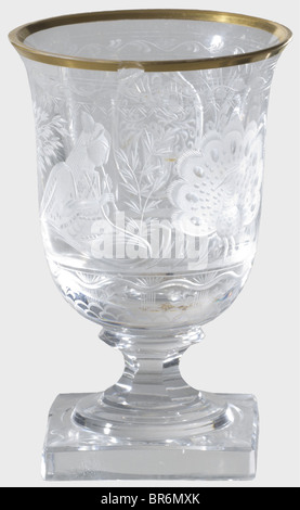 Hermann Göring - a sherry glass, from a hunter's table service. Cut and faceted crystal glass with gold rim (chipped). On the viewing side an Oriental princess seated in a palm grove playing flute to a peacock. The Göring family arms surmounted by a helmet is set in a medallion on the reverse side. Rich floral decoration. Six-sided stem on square foot. Height 10 cm. Provenance: Voluntary auction of the former possessions of Hermann Göring, Neumeister, formerly Weinmülller, 157th auction, 25 October 1974, lot 3061. Presumably a gift for Göring's 50th birthday on, Stock Photo